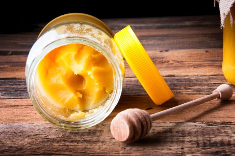 Pot ouvert contenant un miel jaune à la texture cristallisée et crémeuse